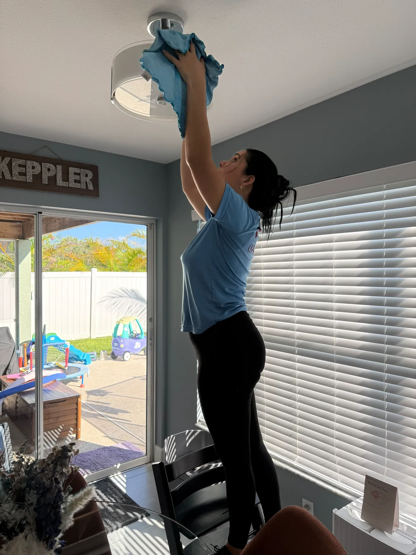 Manatee Ladies cleaner wiping a ceiling light fixture in a Bradenton home