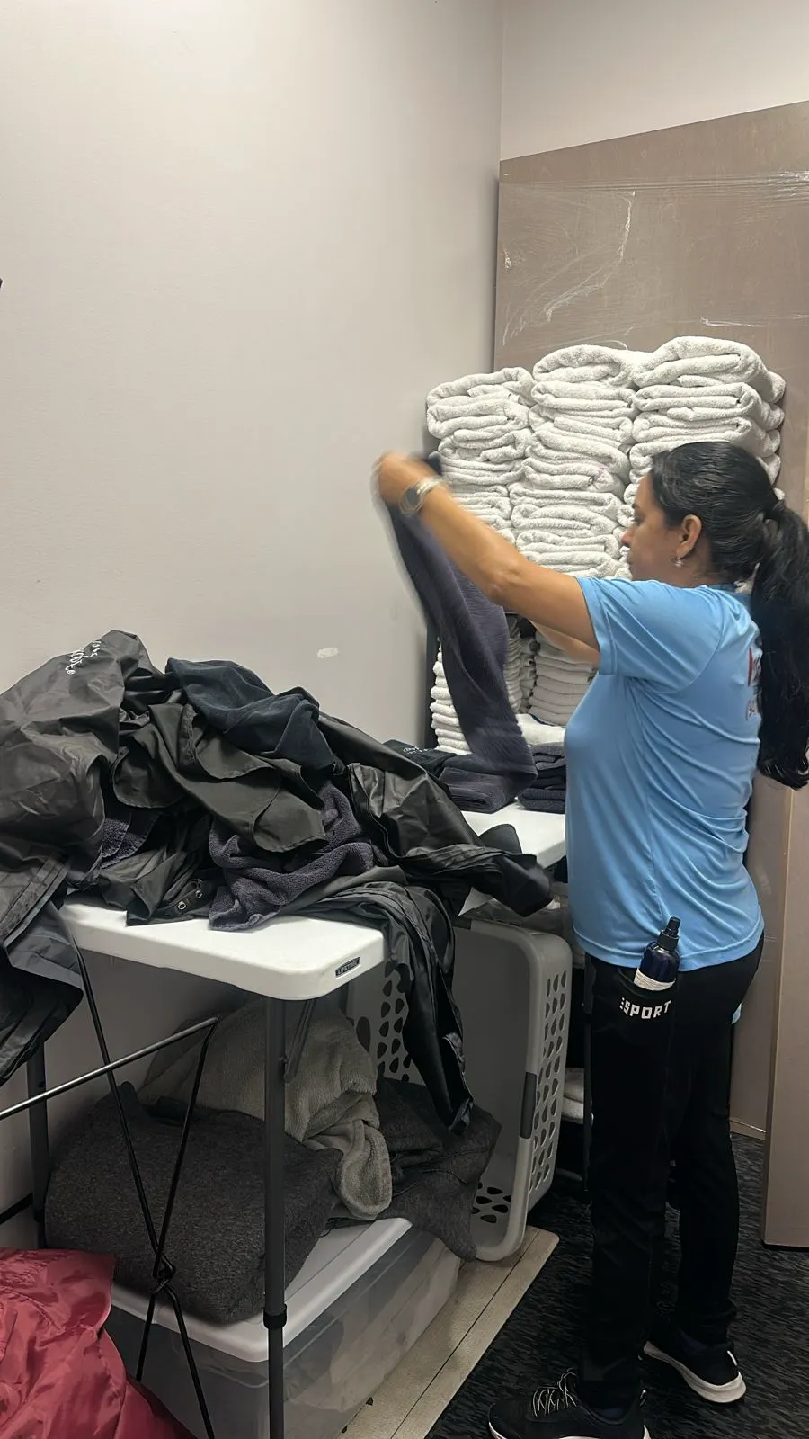 A Manatee Ladies crew member folding fresh linens in a client home