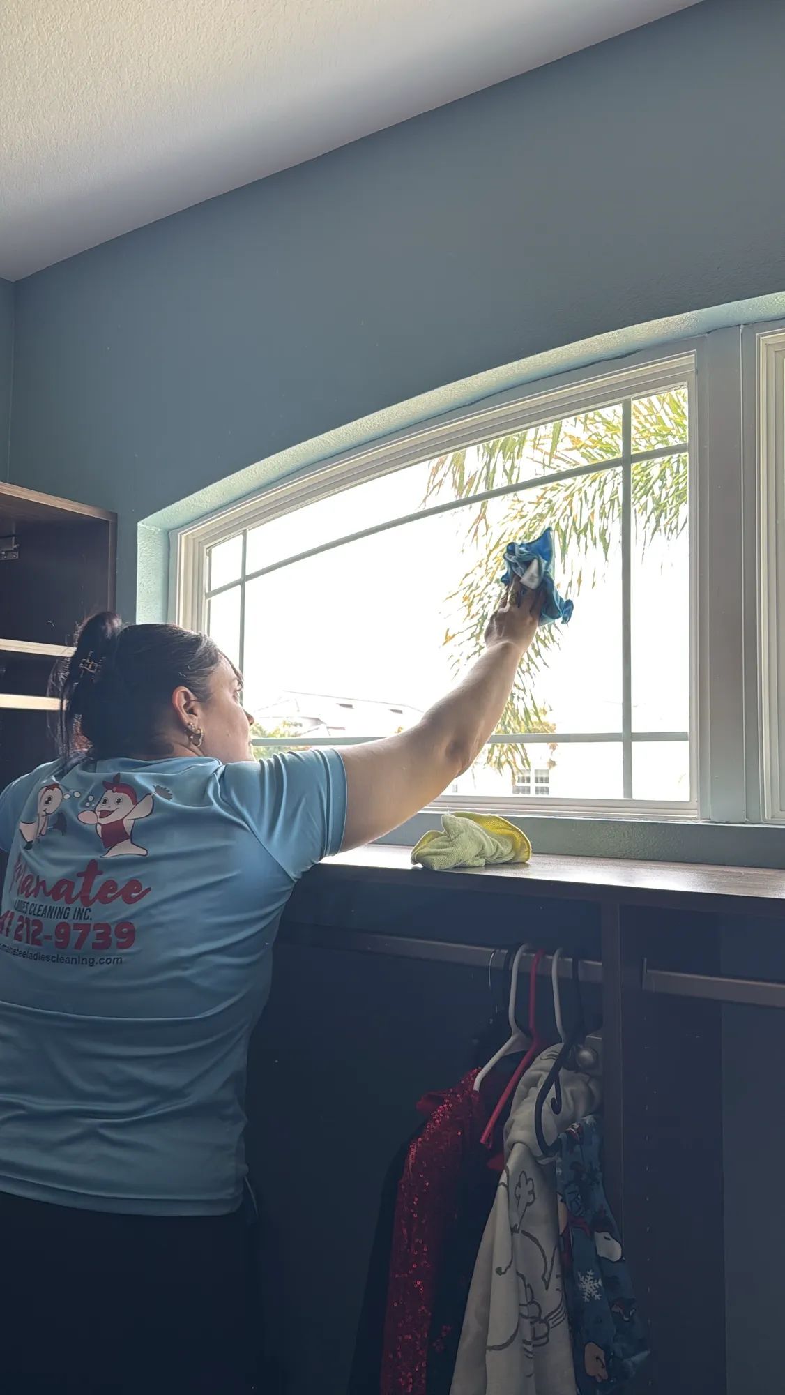 A Manatee Ladies Cleaning crew member in a branded uniform cleaning a Florida home
