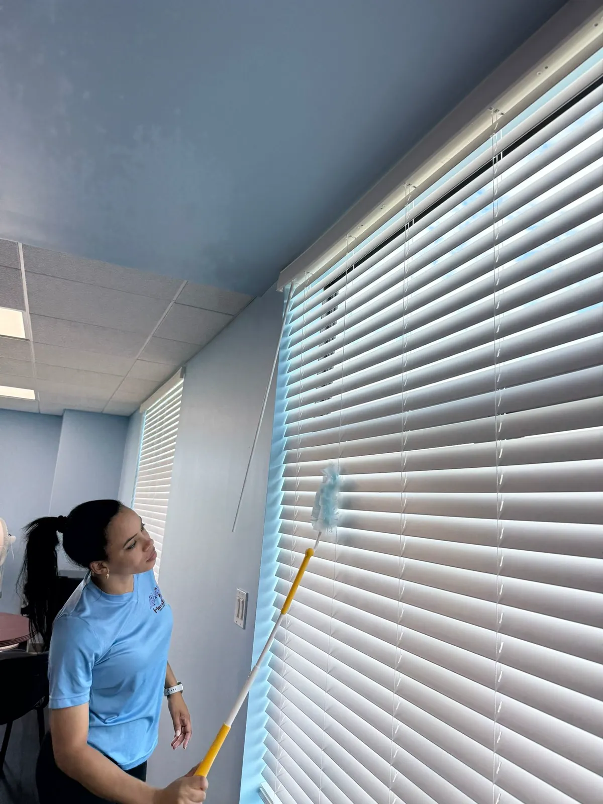 Manatee Ladies cleaner dusting window blinds in a Bradenton office