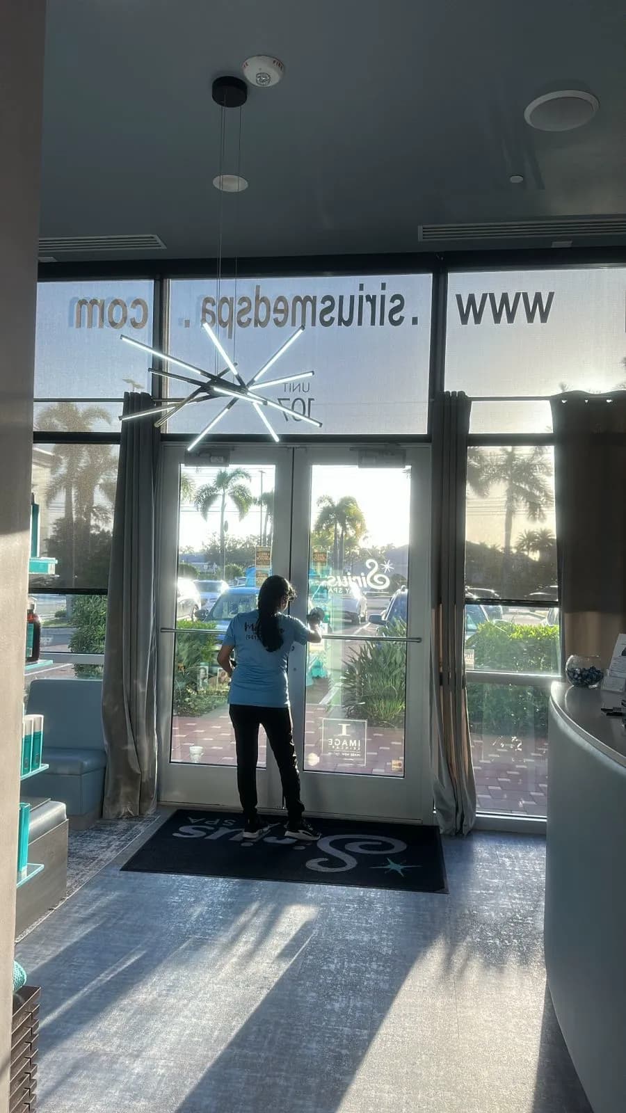 Manatee Ladies cleaner washing the entrance glass at a commercial client in Sarasota